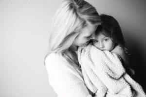 mother holding child with blanket