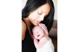 mother holding smiling newborn