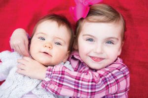 sisters on red blanket