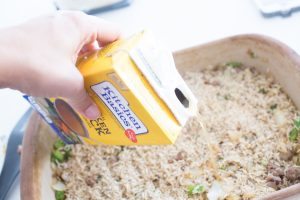 chicken stock being poured into rice
