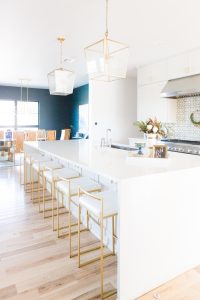 10 Affordable Gold Bar Stools for Home Design large quartz waterfall kitchen island gold langern light fixtures patterned tile backsplash dark green walls dining room -1-2