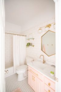 Modern Glam Blush Girls Bathroom Design gold hexagon mirror blush cabinets gold hardware white hexagon floor glass shelves pink bathroom cabinets gold orb sconce-1-3