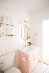 Modern Glam Blush Girls Bathroom Design gold hexagon mirror blush cabinets gold hardware white hexagon floor glass shelves pink bathroom cabinets gold orb sconce-1-3