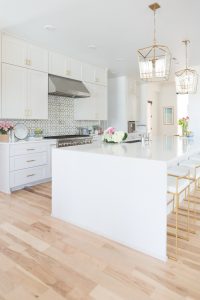 Home and Fashion Memorial Day Sales Weekend gold kitchen lanterns affordable gold bar stools large kitchen island quartz waterfall countertops gold hardware white kitchen cabinets patterned backsplash white kitchen