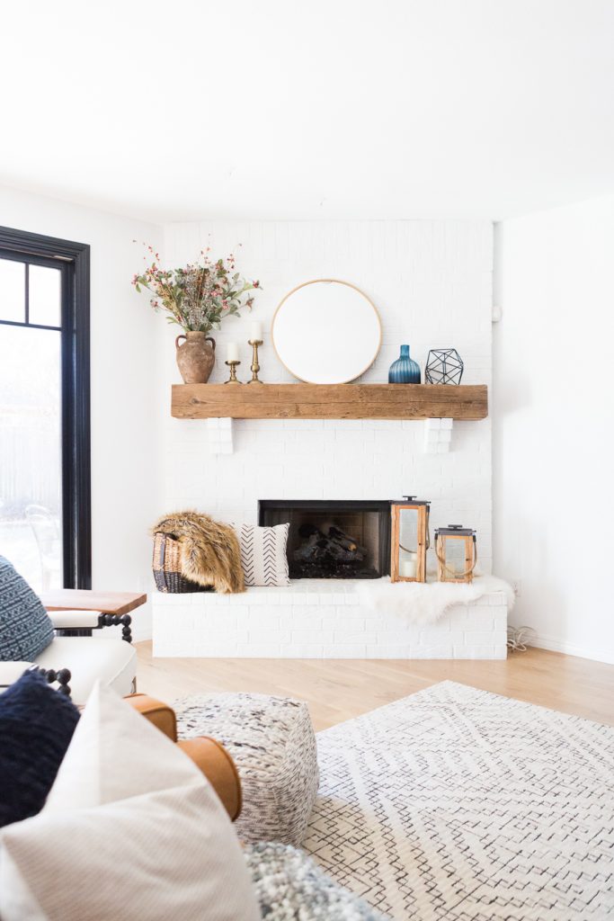 White Painted Brick Fireplace Makeover TV collage wall pottery barn wood media console article sven leather sofa faux fiddle leaf fig tree wood lanterns round gold mirror fireplace styling white walls black windows