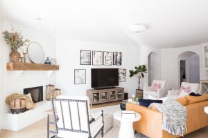 White Painted Brick Fireplace Makeover TV collage wall pottery barn wood media console article sven leather sofa faux fiddle leaf fig tree wood lanterns round gold mirror fireplace styling white walls black windows