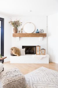 White Painted Brick Fireplace Makeover TV collage wall pottery barn wood media console article sven leather sofa faux fiddle leaf fig tree wood lanterns round gold mirror fireplace styling white walls black windows