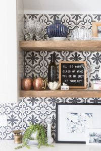 Affordable Ceramic Patterned Tile Backsplash affordable cement tile lookalike black and white patterned tile backsplash open wood shelves kitchen open wood shelves styling ideas how to style open wood shelving blue west elm vase wooden picture frames greige cabinets