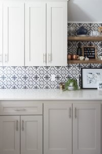 Affordable Ceramic Patterned Tile Backsplash affordable cement tile lookalike black and white patterned tile backsplash open wood shelves kitchen open wood shelves styling ideas how to style open wood shelving blue west elm vase wooden picture frames greige cabinets