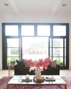 How to Design a Beautiful Pool and Outdoor Living Area black windows and doors Anderson sliding aluminum clad doors faux pink stems modern glam decor gold coffee table chocolate velvet couch velvet sofa u shaped home design