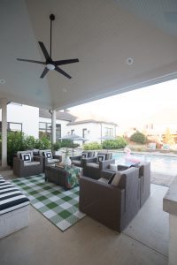 How to Design a Beautiful Pool and Outdoor Living Area buffalo check outdoor rug Target outdoor club chairs black and white outdoor pillows cement countertops outdoor living area decor ideas wicker pool lounger best affordable pool loungers black and white outdoor umbrellas rectangle pool design large rectangular pool with sunken hot tub most beautiful rectangle pools concrete pavers with mondo grass concrete pavers with grass growing between them white brick house with black windows and doors