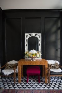 Loveliest Looks of Fall Home Tour Beautiful Fall Home Decor and Fall Fashion Ideas entryway with black paneling painted high gloss and marble black and white floors with a burl wood console table and a white mirror hanging about it and a silver urn floral pumpkin centerpiece sitting on the table