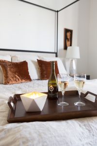 Simple Ways to Decorate for the Holidays from West Elm master bedroom with a canopy bed and a copper chunky knit throw and copper rust velvet pillows