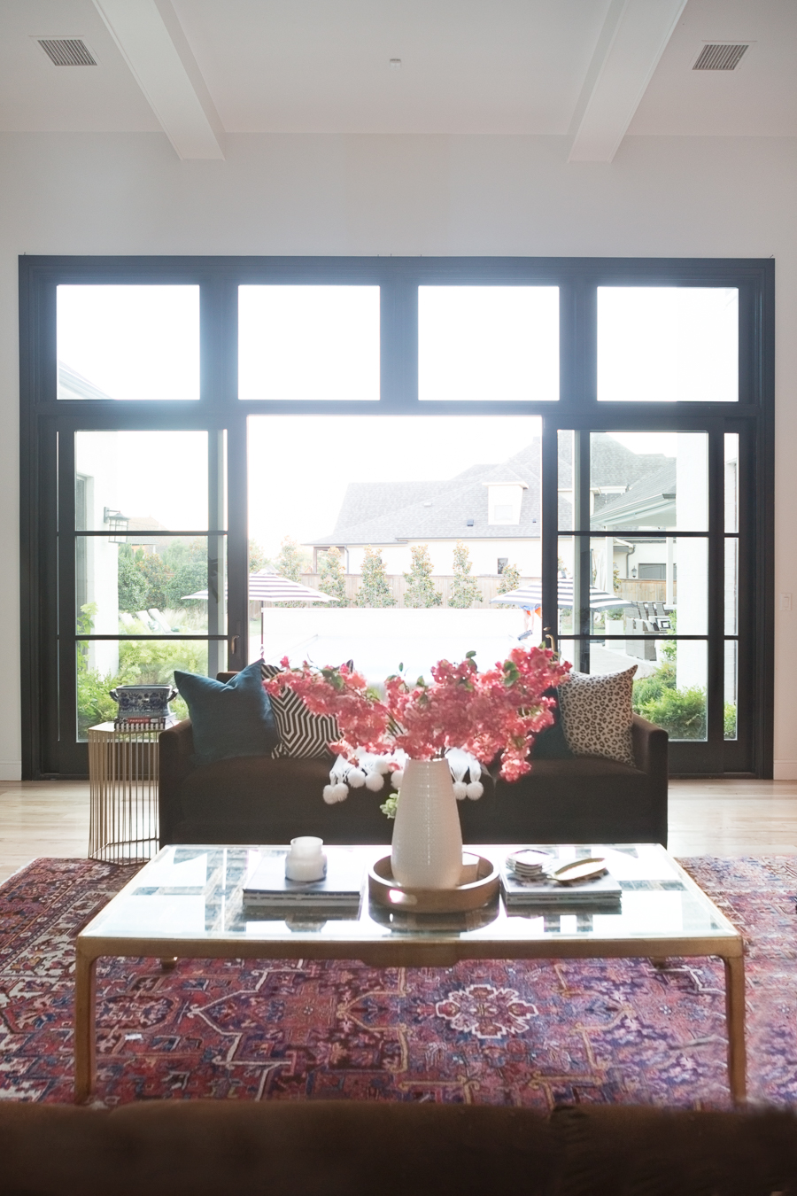 HOW TO FIND BLACK WINDOWS AND DOORS FOR LESS in a beautiful elcletic living room with flowers on the coffee table