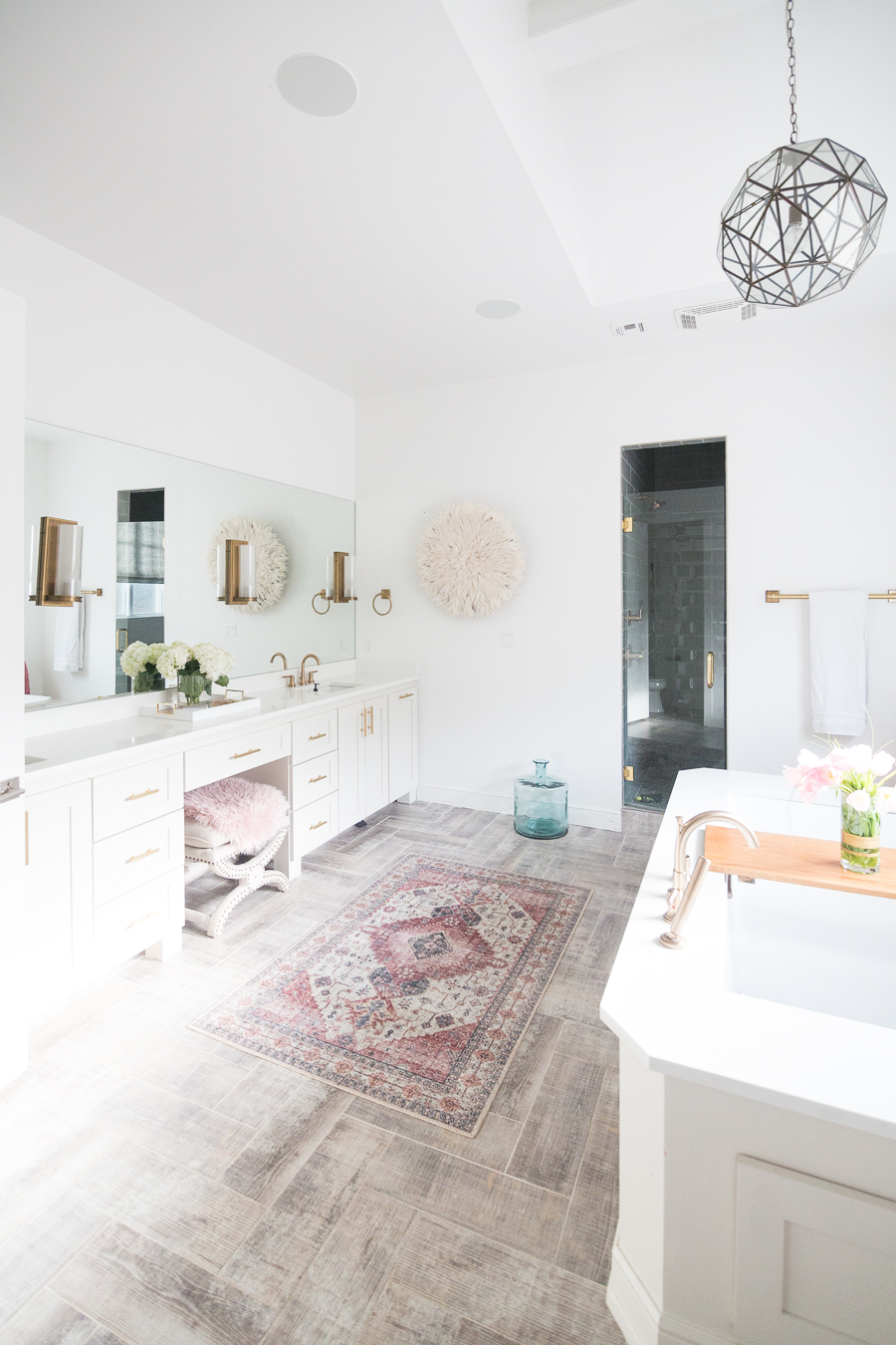 CC's sunday favorites loloi skye berry rug in a master bathroom with white cabinets and gold lighting and hardware with wood grain tile floors-1