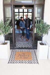 Easy Spring Front Porch Makeover Ideas CC and Mike standing on the front porch of their white brick modern home with black aluminum clad windows and doors -1-2