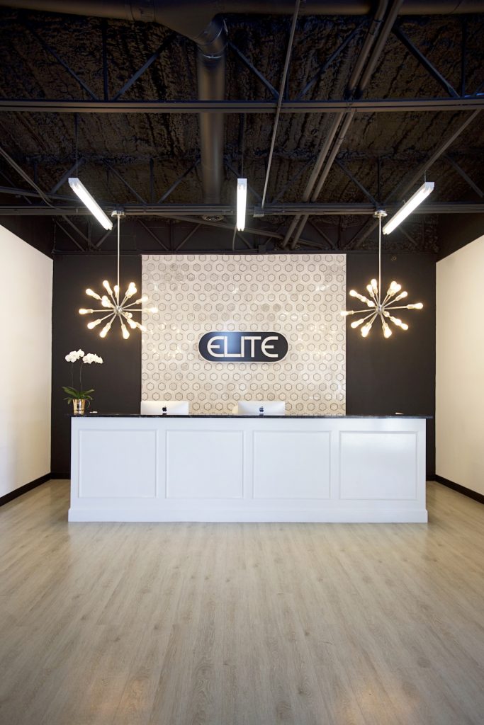 elite dance studio front desk with a white front desk and gorgeous chandeliers