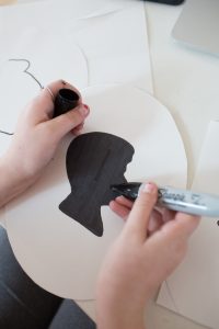 coloring in a boy's silhouette with black marker