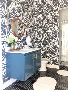 Vintage Chic Bathroom Update black hexagon floors with a green floating vanity and a wood mirror palm frond wallpaper