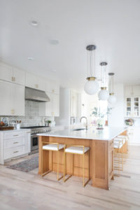 CC and MIke Kitchen Remodel Reveal large natural wood island with quartz countertops and gold bar stools black and gold pendants Ann sacks patterned backsplash gold Brizo faucet large Kallista stainless steel sink open floorpan