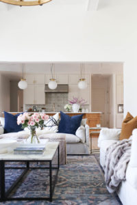 CC and MIke Kitchen Remodel Reveal large natural wood island with quartz countertops and gold bar stools living room with navy rug slipcover crypton fabric navy Hathaway navy velvet pillows leopard ottomans marble coffee tables