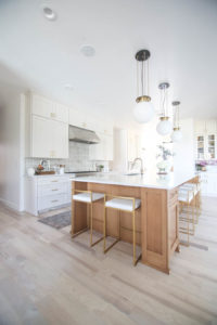 CC and MIke Kitchen Remodel Reveal large natural wood island with quartz countertops and gold bar stools black and gold pendants Ann sacks patterned backsplash gold Brizo faucet large Kallista stainless steel sink open floorpan