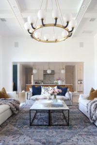 CC and MIke Kitchen Remodel Reveal large natural wood island with quartz countertops and gold bar stools living room with navy rug slipcover crypton fabric navy Hathaway navy velvet pillows leopard ottomans marble coffee tables