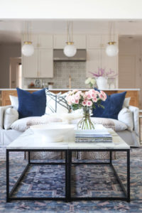 CC and MIke Kitchen Remodel Reveal large natural wood island with quartz countertops and gold bar stools living room with navy rug slipcover crypton fabric navy Hathaway navy velvet pillows leopard ottomans marble coffee tables