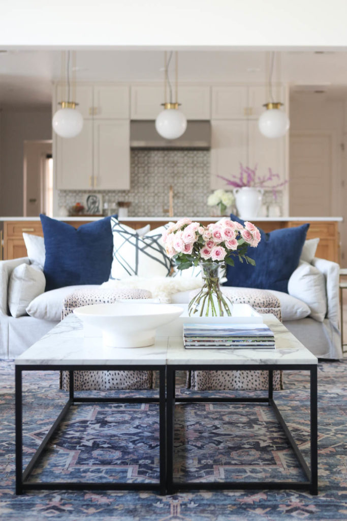 CC and MIke Kitchen Remodel Reveal large natural wood island with quartz countertops and gold bar stools living room with navy rug slipcover crypton fabric navy Hathaway navy velvet pillows leopard ottomans marble coffee tables