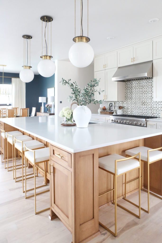 CC and MIke Kitchen Remodel Reveal large natural wood island with quartz countertops and gold bar stools black and gold pendants Ann sacks patterned backsplash gold Brizo faucet large Kallista stainless steel sink open floorpan