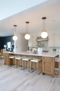 CC and MIke Kitchen Remodel Reveal large natural wood island with quartz countertops and gold bar stools black and gold pendants Ann sacks patterned backsplash gold Brizo faucet large Kallista stainless steel sink open floorpan