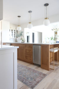 CC and MIke Kitchen Remodel Reveal large natural wood island with quartz countertops and gold bar stools black and gold pendants Ann sacks patterned backsplash gold Brizo faucet large Kallista stainless steel sink open floorpan