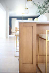 CC and MIke Kitchen Remodel Reveal large natural wood island with quartz countertops and gold bar stools black and gold pendants Ann sacks patterned backsplash gold Brizo faucet large Kallista stainless steel sink open floorpan