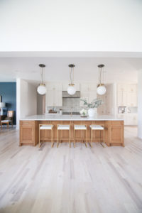 CC and MIke Kitchen Remodel Reveal large natural wood island with quartz countertops and gold bar stools black and gold pendants Ann sacks patterned backsplash gold Brizo faucet large Kallista stainless steel sink open floorpan